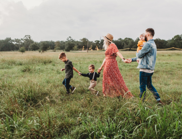 Famille de trois enfants qui marche dans un champ