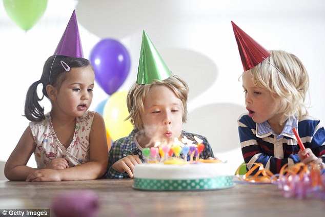 Enfant qui souffle ses bougies d'anniversaire avec ses amis